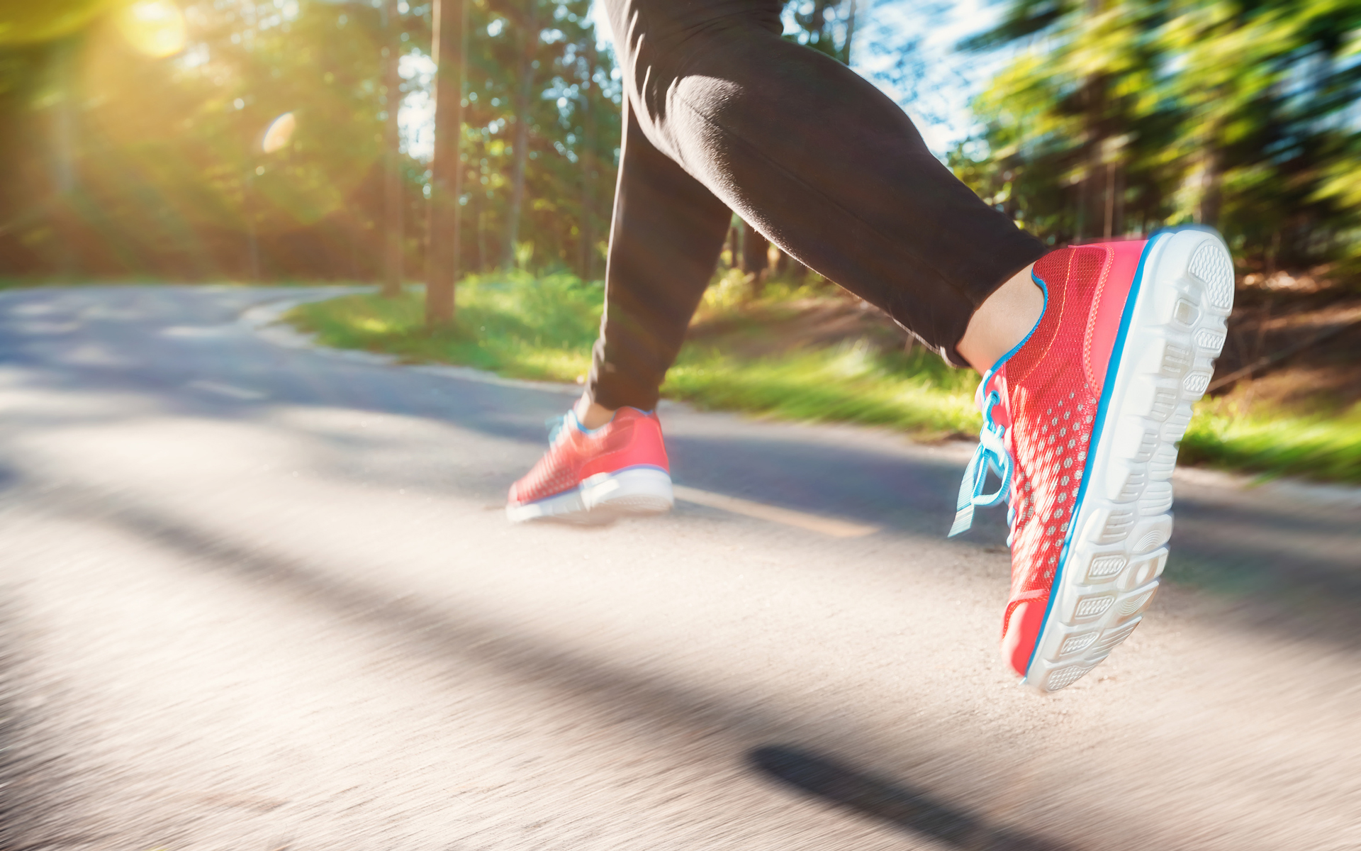 Sportangebot Eine Joggerin springt über den Asphalt